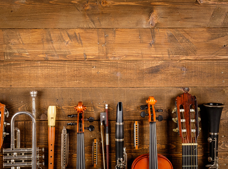 verschiedene Instrumente liegen nebeneinander auf einem Holzboden.